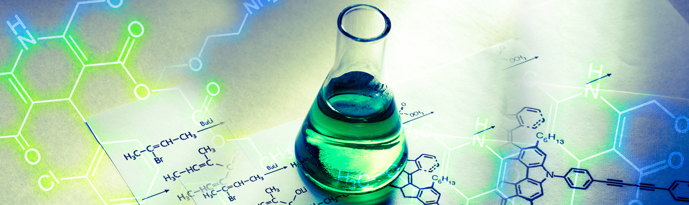 Composición de un tubo químico conteniendo una sustancia líquida verde junto a una fórmula de reacción escrita en papel.